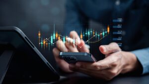Manos masculinas utilizando un celular que muestra datos de crecimiento.