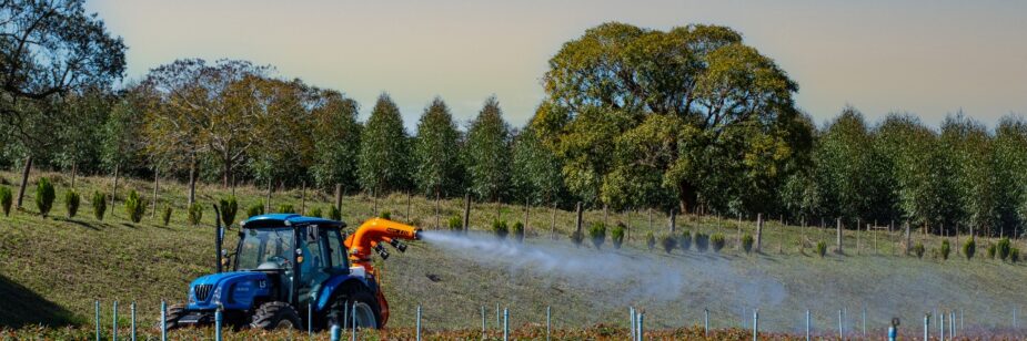 Máquina agrícola esparciendo fertilizante en un cultivo.