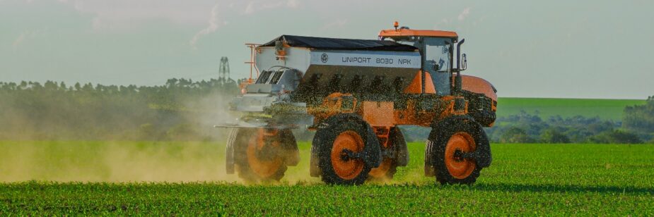 Máquina agrícola esparciendo fertilizantes en tierras para cultivo.