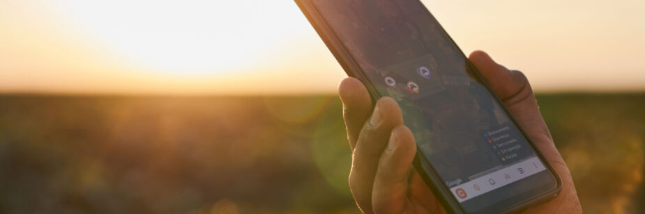 Mano masculina sosteniendo un celular que muestra la ubicación vía Bluetooth.