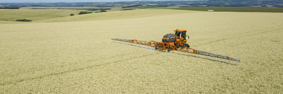 Pulverizador autopropulsado Jacto Uniport 2000 Plus pulverizando en un campo de trigo