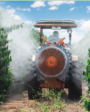 Pulverización en el café con equipo asistido por aire acoplado a un tractor entre hileras de cafetos.